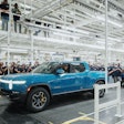 Rivian CEO RJ Scaringe is shown behind the wheel of the nation's first mass-produced electric pickup, the R1T.