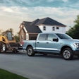 A photo released by Ford shows the 2022 F-150 Lightning towing a track loader.
