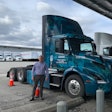 DHE’s director of process improvement Troy Musgrave stands beside one of three Volvo VNR Electrics at their facility in Ontario, California.