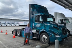 DHE’s director of process improvement Troy Musgrave stands beside one of three Volvo VNR Electrics at their facility in Ontario, California.