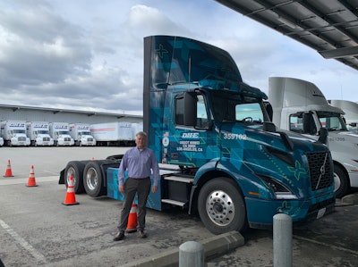 DHE’s director of process improvement Troy Musgrave stands beside one of three Volvo VNR Electrics at their facility in Ontario, California.