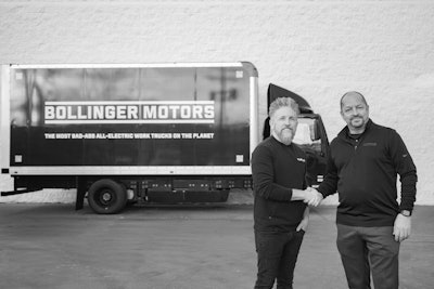 Two men shake hands in front of a Bollinger Motors truck.