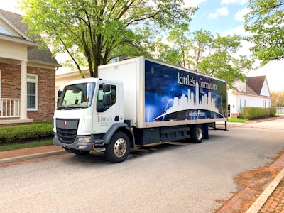 A Kenworth K270E Battery-Electric Cabover parked outside a home.