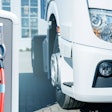 An electric truck next to a charging station.