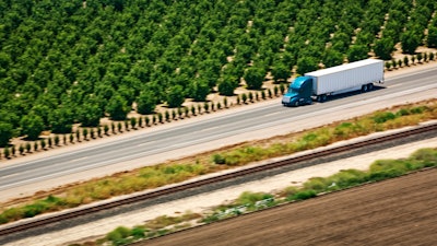 Truck on highway passing trees in California