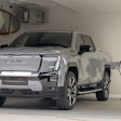 silver 2024 GMC Sierra Denali EV plugged in to charger