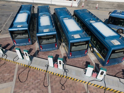 Electric transit buses parked and charging