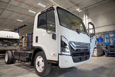 A white electric Isuzu truck on the assembly line
