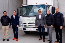 Five men stand in front of an electric Isuzu truck.