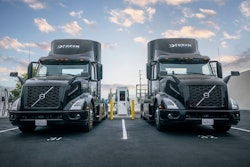 A pair of EV semis charge