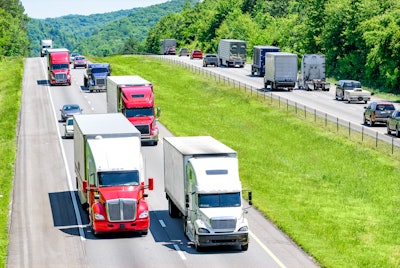 An interstate highway with traffic, including trucks.