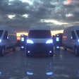 A rendering of battery-electric commercial vans parked at charging stations.