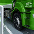 A rendering of an electric semi truck plugged in at a charging station.