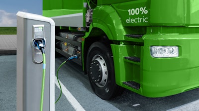 A rendering of an electric semi truck plugged in at a charging station.