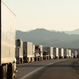 Semi trucks lined up on a crowded California highway.