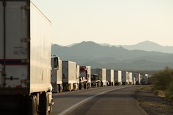 Semi trucks lined up on a crowded California highway.