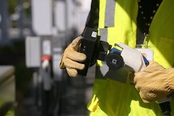 A ChargeHelp! technician is shown testing an EV charging connector.