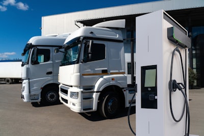 Examples of battery-electric semis parked at a charging station.
