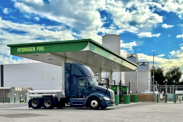 A hydrogen fuel cell Class 8 is shown at a green hydrogen refueling station.