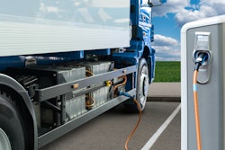 A battery-electric semi truck charging at a station, illustrating EV infrastructure in action.