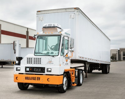 An example of an Orange EV electric yard tractor hauling a trailer.
