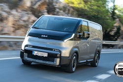 The all-new battery-electric Kia PV5 van driving on a mountain highway.
