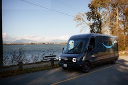 A Rivian Electric Delivery Van operates against the Vancouver skyline as Amazon launches its first EV fleet in Canada.