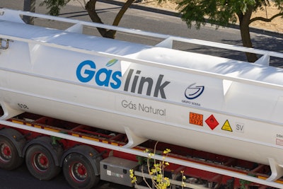 A white Gaslink natural gas tanker truck shown parked on the roadside.