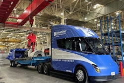 RoadOne's newly acquired blue Tesla Semi unloads aluminum coils inside a warehouse.