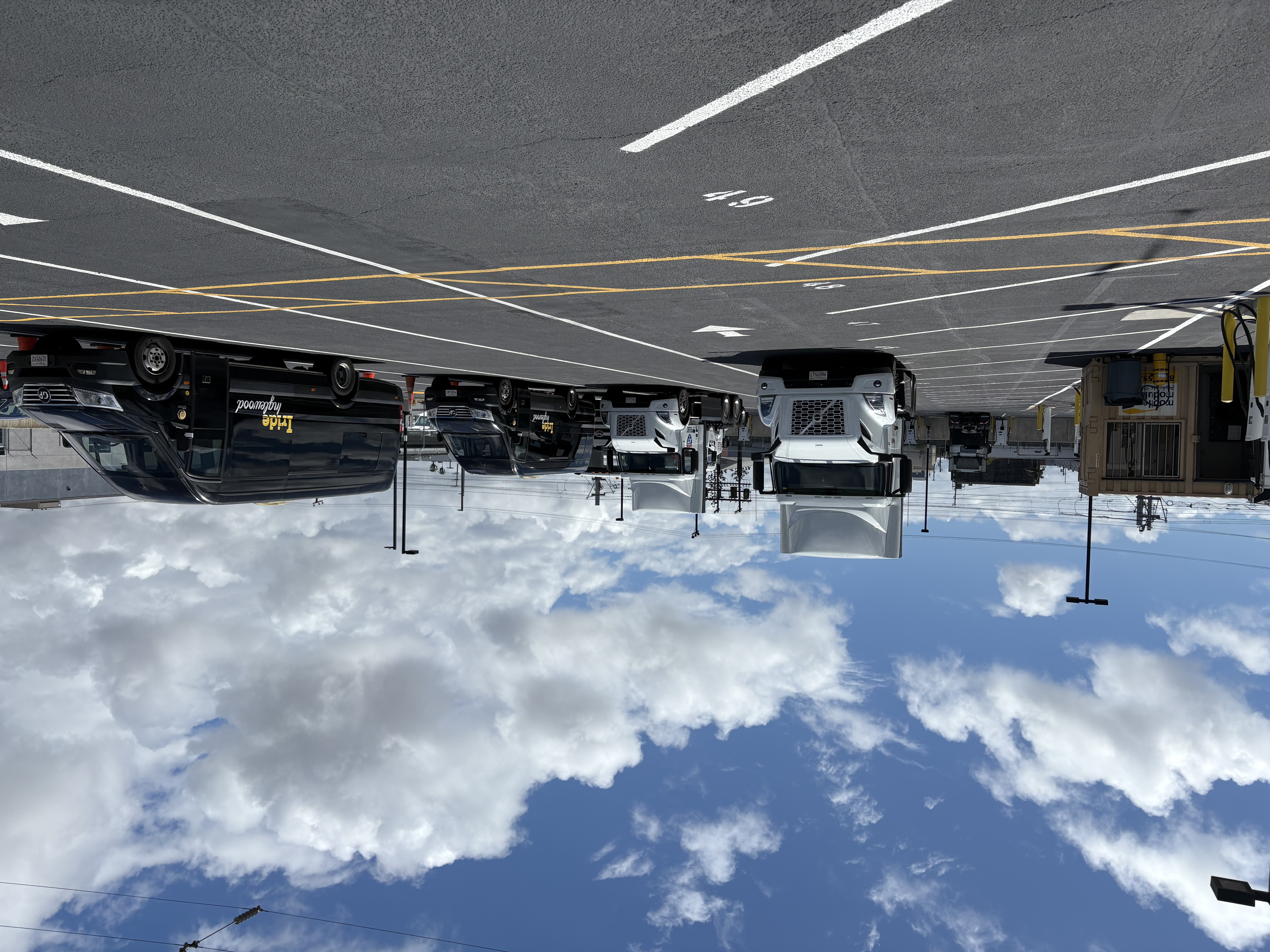 Zeem Solutions' LAX depot, featuring parked Volvo VNR Electric Class 8 semis and Mercedes-Benz eSprinter vans.