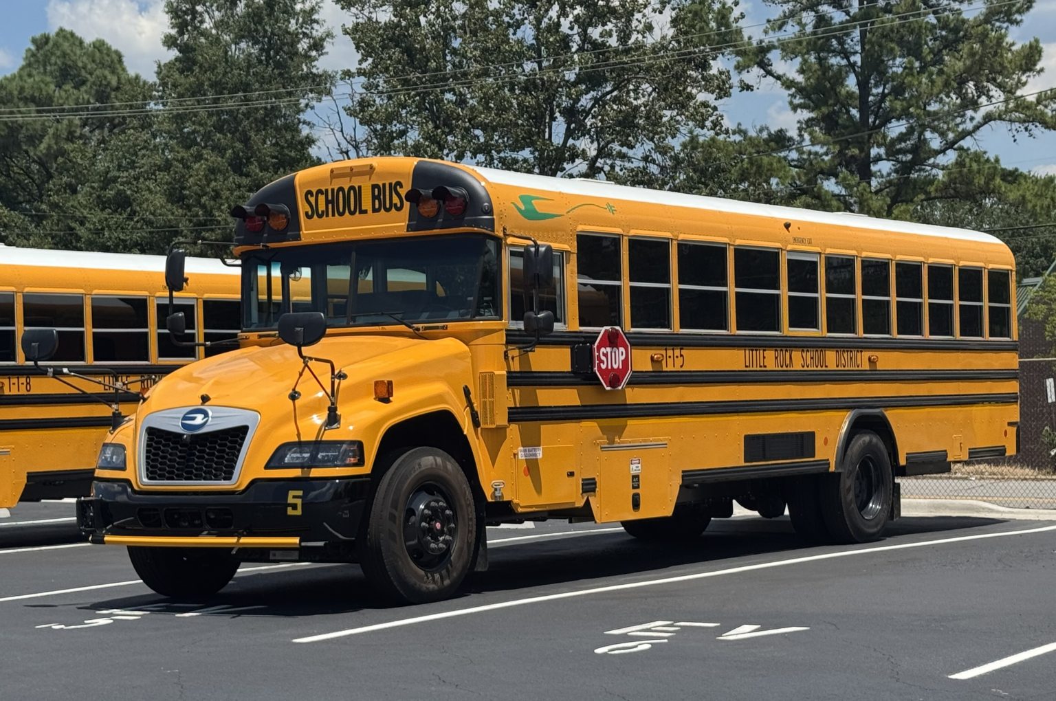 A yellow battery-electric school bus built by Blue Bird is parked.