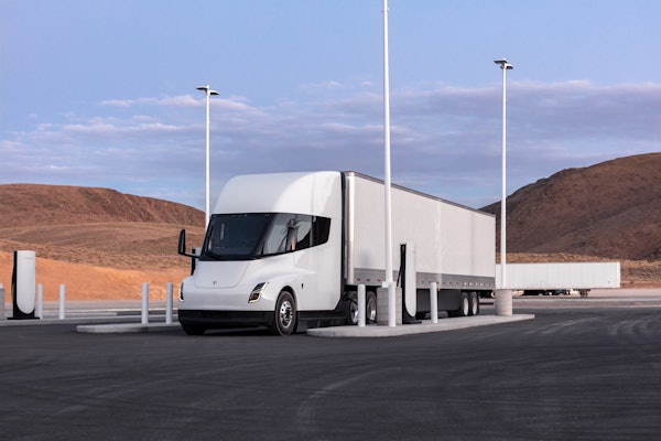 A rendering of a white Tesla Semi at a charging station.