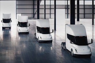 A rendering of four Tesla Semi battery-electric Class 8 trucks parked inside a warehouse.