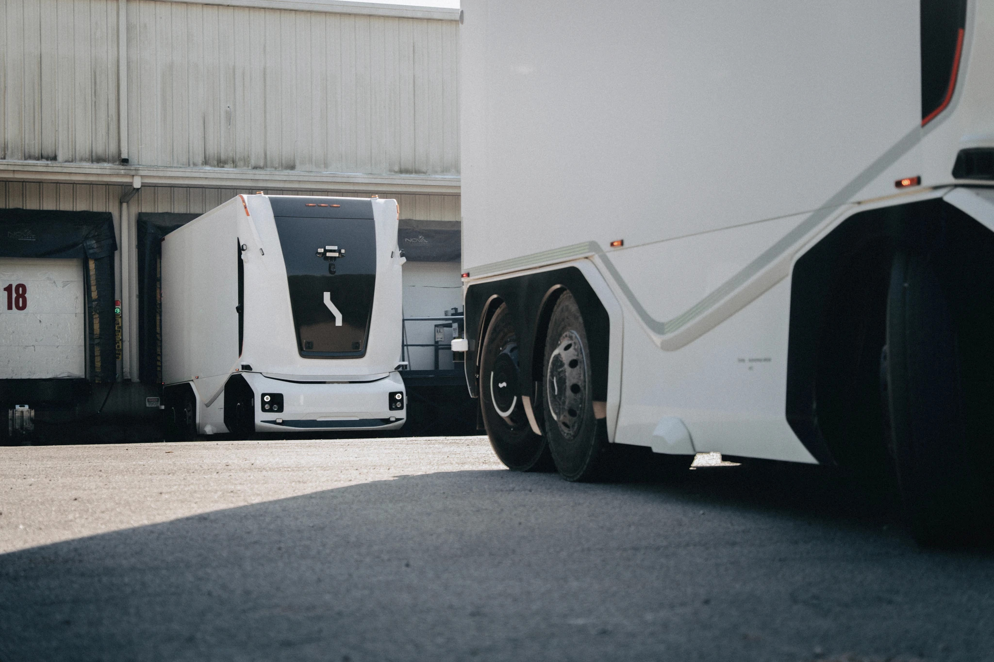 Einride's battery-electric autonomous trucks in action at an industrial warehouse.