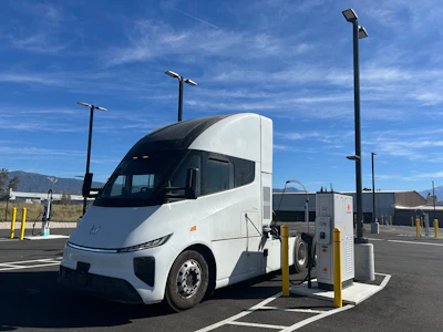 A white Windrose R700 semi-truck connected to a Kempower MCS charger at EV Realty's San Bernardino hub.