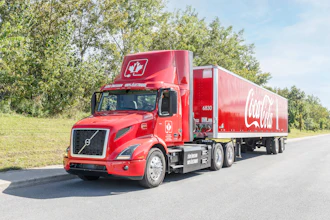 Coke Canada Bottling's read Volvo VNR Electric hauling a red Coca-Cola trailer.