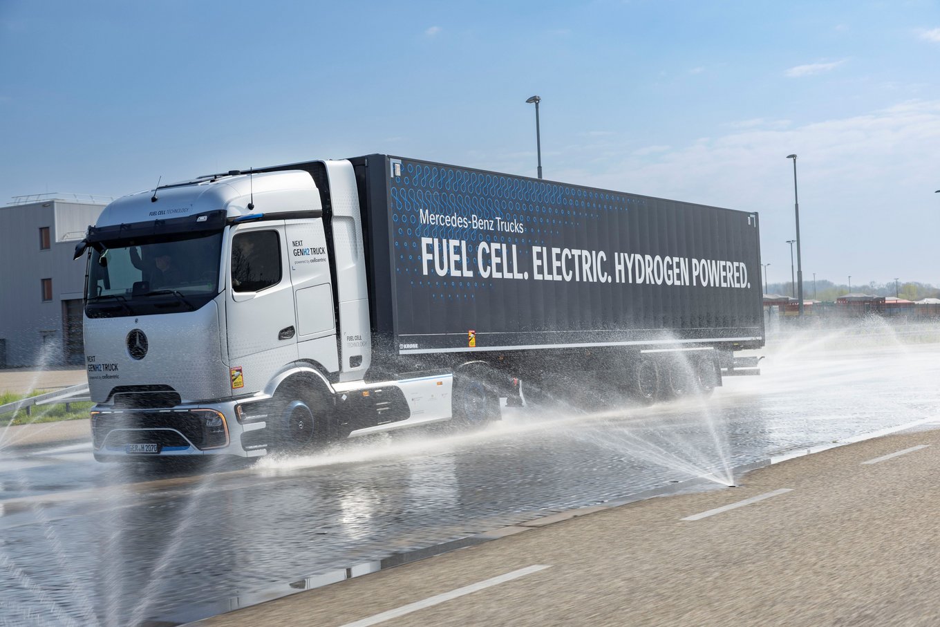 Mercedes-Benz's NextGenH2 hydrogen fuel cell truck undergoes a wet pavement handling test, with water sprayed across the surface to simulate real-world conditions.