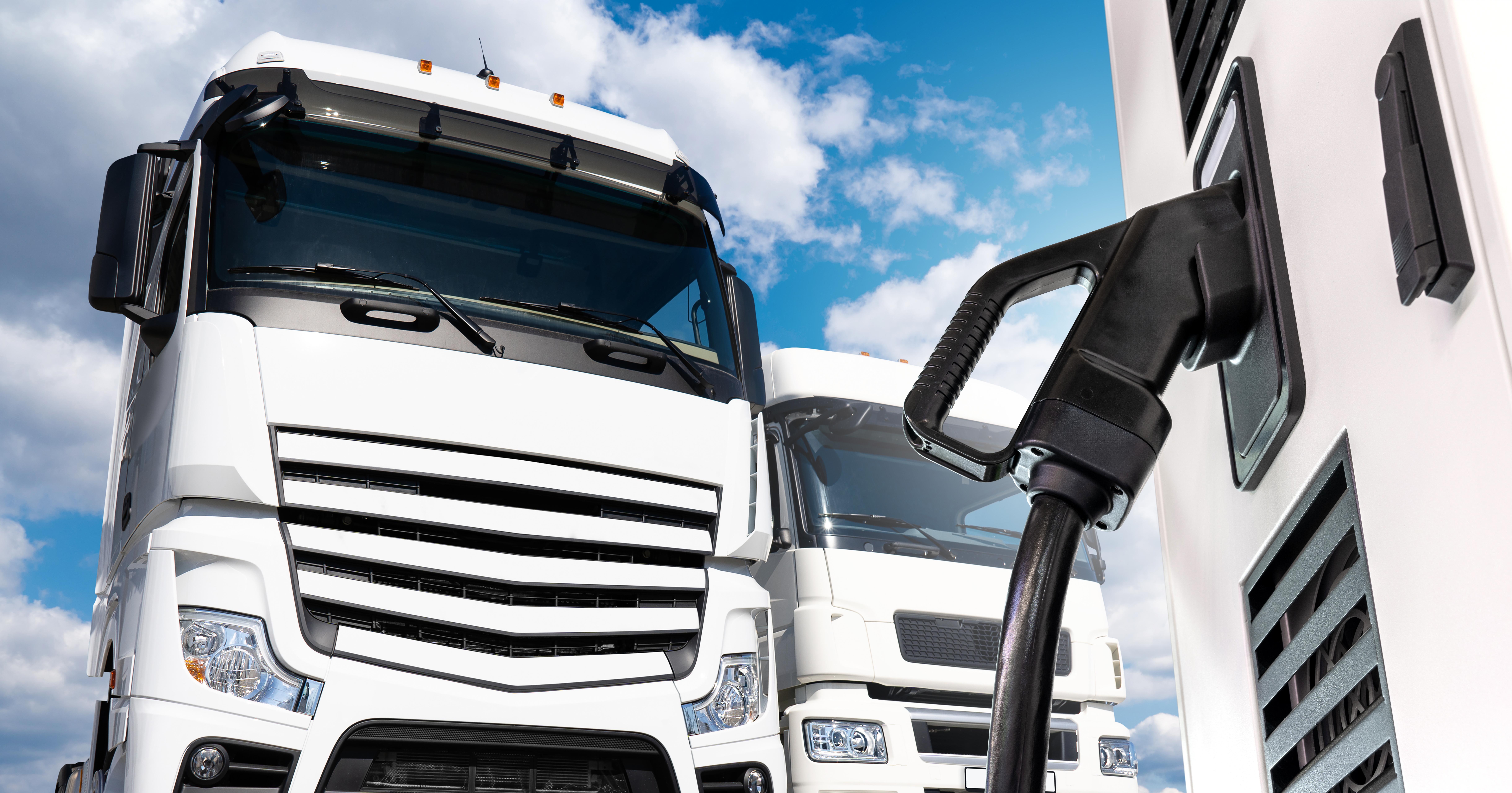 A rendering of a commercial semi-truck connected to a charging cable.