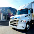 The new battery-electric Hino Trucks LE Series truck sits parked outside a building.