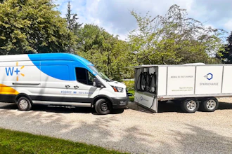 A battery-electric Walmart delivery van connected to a SparkCharge mobile charging unit for on-demand fleet charging.
