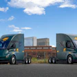 Two ArcBest-branded Tesla Semi trucks parked outside an ABF Freight facility.