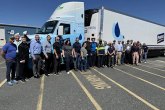 Employees from Optimus Technologies, Perdue Farms, and the Maryland Soybean Board stand in front of a biodiesel-powered Volvo semi-truck.