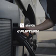 An individual is shown charging an electric semi-truck with the Einride and Flipturn brand logos on display.