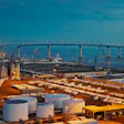 The Port of San Diego at dusk, with shipping containers and storage tanks visible throughout the terminal.