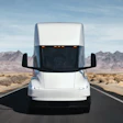 A front view of the updated Tesla Semi driving along a highway.