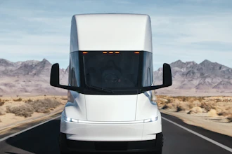 A front view of the updated Tesla Semi driving along a highway.